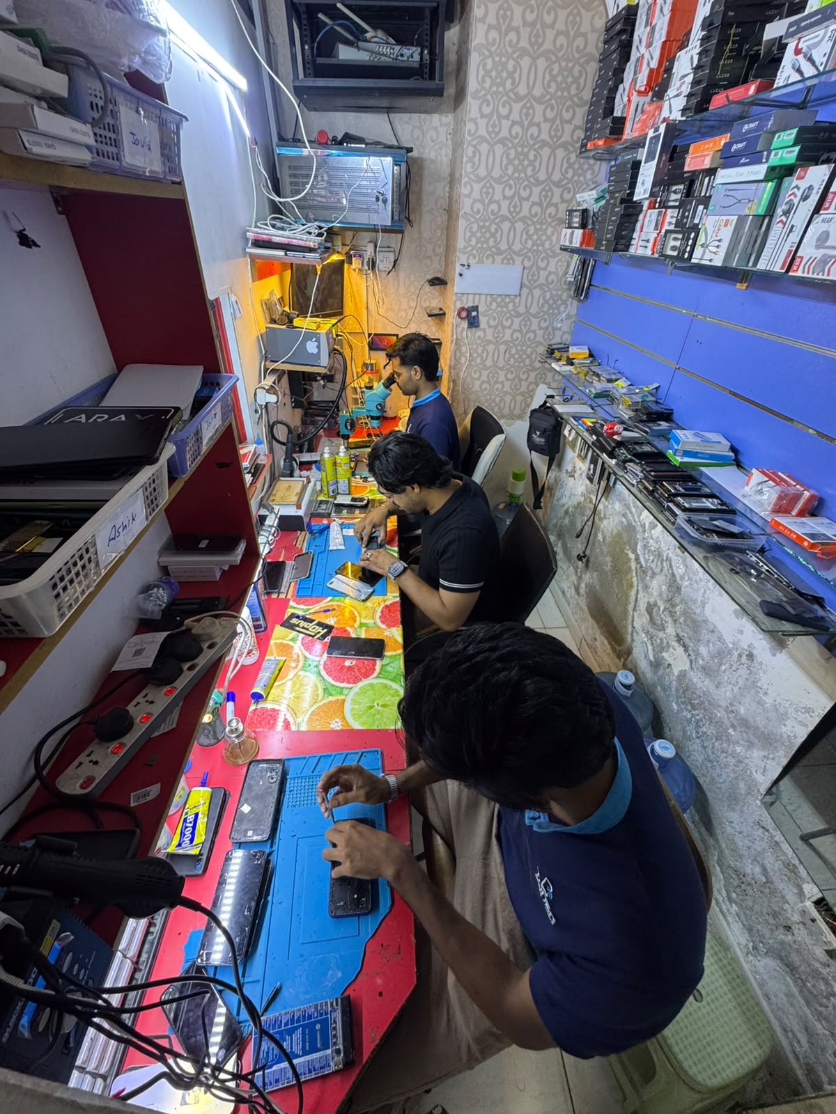 Technicians testing and checking used phones in store